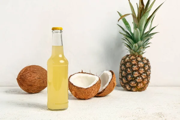 光を背景にココナッツとパイナップルと新鮮なソーダのボトル — ストック写真