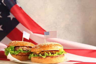 Lezzetli hamburgerler ve arka planda Amerikan bayrağı. Anma Günü kutlaması