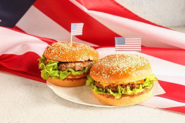 Lezzetli hamburger tabağı ve arka planda Amerikan bayrağı. Anma Günü kutlaması