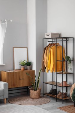 Raflar ve kıyafetlerle aydınlık oturma odasının içinde.