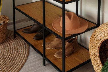 Oturma odasında şapkası ve ayakkabısı olan raf ünitesi.