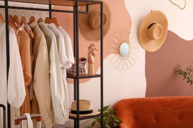 Odanın duvarına yakın raflarda giysi ve aksesuarlar var.