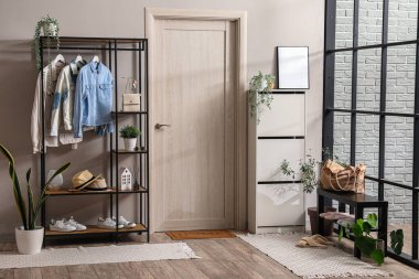 Rafları, çekmeceleri ve ayakkabı standı olan modern salonun içi.