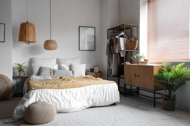 Raflar ve kıyafetlerle aydınlık yatak odasının içinde.