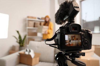 Evde kamera önünde ayakkabı kutuları olan kadın satıcı, yakın plan.