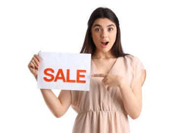 Şaşkın kadın satıcı beyaz arka plandaki indirimli tabelayı işaret ediyor.