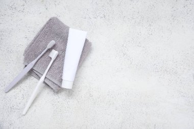 Arkaplanda havlu bulunan plastik diş fırçaları ve yapıştırıcılar