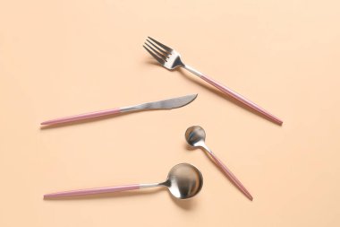 Bej arkaplanda şık çatal bıçak takımı
