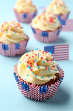 Mavi arka planda ABD bayrakları olan lezzetli vatansever kapkekler. Amerikan Bağımsızlık Günü