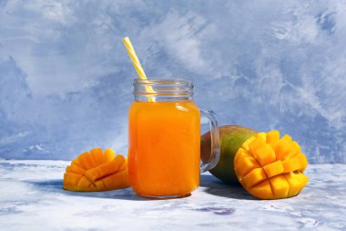 Mason kavanozu mavi arka planda taze mango smoothie.