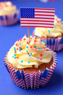 Mavi arka planda ABD bayrakları olan lezzetli vatansever kapkekler. Amerikan Bağımsızlık Günü