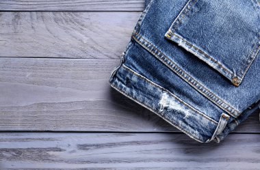 Mavi ahşap arka planda farklı bir kot pantolon.