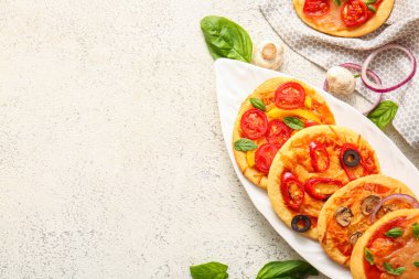 Beyaz arka planda farklı lezzetli pizzalar olan tabaklar.