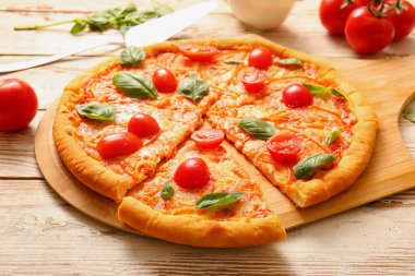 Beyaz ahşap arka planda lezzetli pizza margaritası olan bir pano.