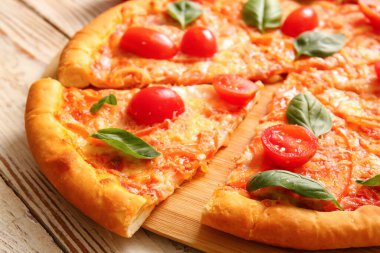 Beyaz ahşap arka planda lezzetli pizza margaritası olan bir pano.