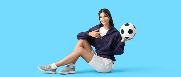 Mladá Žena Fotbalovým Míčem Sedí Modrém Pozadí — Stock fotografie