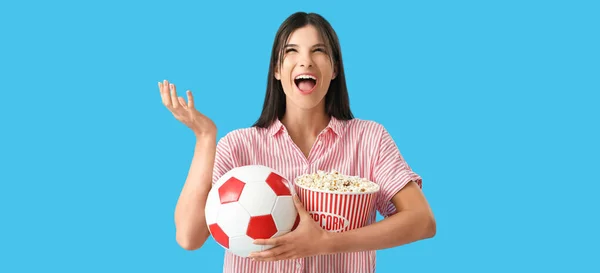 快乐的女球迷 带着爆米花和蓝色背景的球 — 图库照片