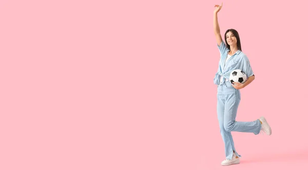 快乐的年轻女子 带着粉色背景的足球 带着文字的空间 — 图库照片