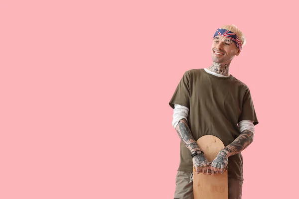 Tatuerad Ung Man Med Skateboard Rosa Bakgrund — Stockfoto