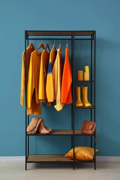 青い壁の近くの服や靴の棚ユニット — ストック写真