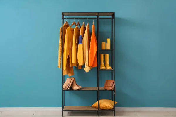青い壁の近くの服や靴の棚ユニット — ストック写真