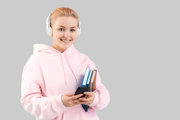 Jonge Vrouw Hoofdtelefoon Met Boeken Grijze Achtergrond — Stockfoto