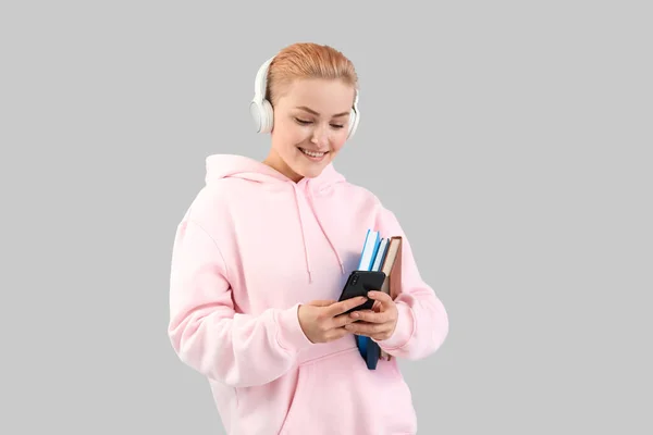 Jeune Femme Dans Casque Avec Des Livres Utilisant Téléphone Portable — Photo
