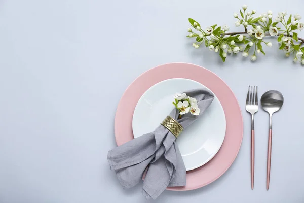 灰色の背景に開花木の枝と美しいテーブルの設定 — ストック写真