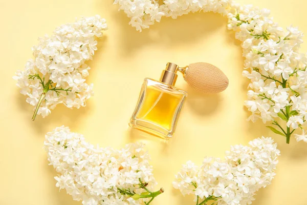 淡い黄色の背景に美しいライラックの花や香水のボトルで作られたフレーム — ストック写真