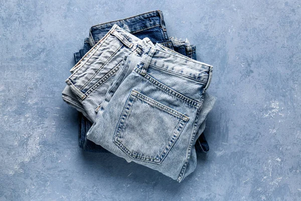 Different Folded Denim Jeans Grunge Blue Background — Stock Photo, Image