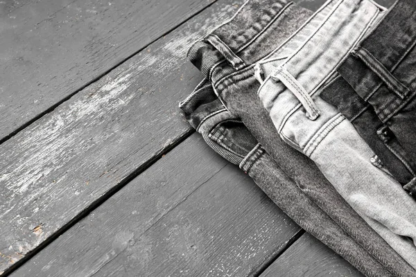 Różne Stylowe Jeansy Jeansowe Szarym Drewnianym Tle — Zdjęcie stockowe