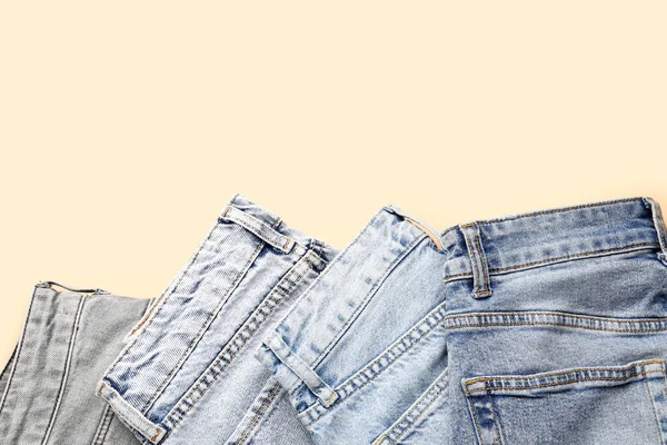 Soluk Turuncu Arka Planda Farklı Stil Katlanmış Kot Pantolon — Stok fotoğraf