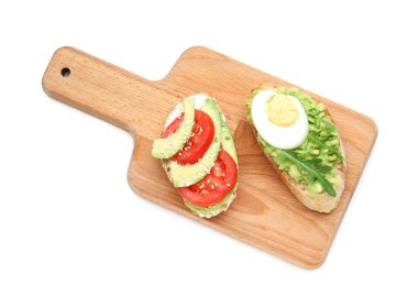 Avokadolu lezzetli bruschettalar ve beyaz arka planda domatesler.