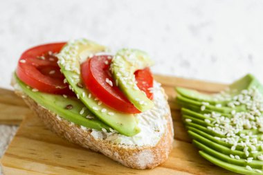 Avokado ve domatesli lezzetli bruschetta tahtası, yakın plan.