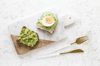 Hafif arka planda lezzetli avokado tostları.