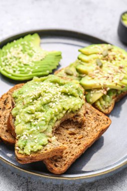 Hafif arka planda lezzetli avokado tostları, yakın plan.