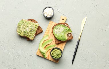 Hafif arka planda lezzetli avokado tostları tahtası.