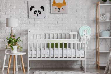 Bebek karyolasıyla aydınlık yatak odasının içi