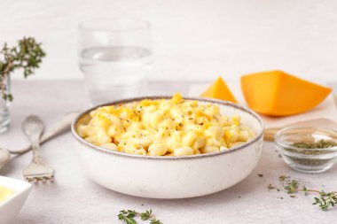 Hafif arka planda Çedar peynirli bir kase lezzetli İtalyan makarnası.