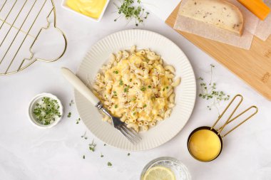 Açık arkaplanda Çedar peynirli bir tabak lezzetli İtalyan makarnası.