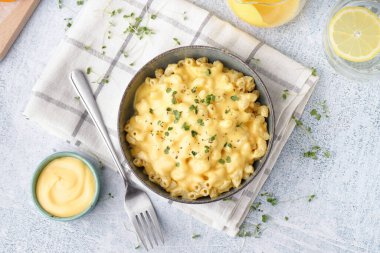 Hafif arka planda Çedar peynirli bir kase lezzetli İtalyan makarnası.