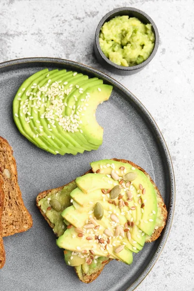 stock image Plate of tasty avocado toast on light background, closeup