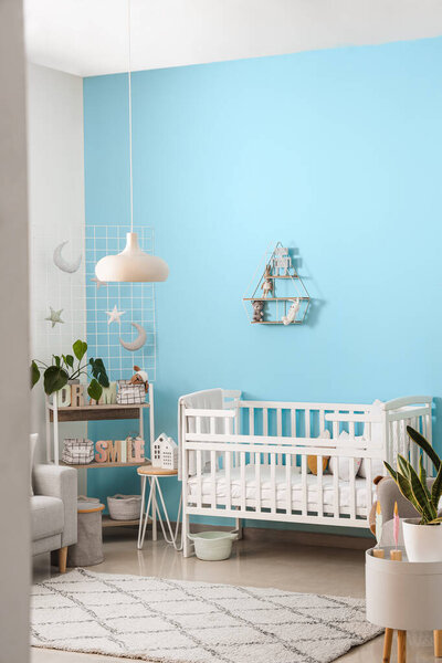 Interior of stylish bedroom with baby crib and shelving unit