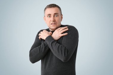 Hafif arka planda korkmuş olgun bir adam.