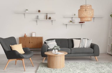 Oturma odası, siyah kanepe, koltuk ve ahşap sehpa.