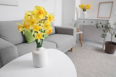 Oturma odasındaki sehpanın üzerinde çiçek açan vazo.