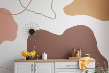 Çiçek açan narsist çiçeklerle süslenmiş şık bir mutfak.