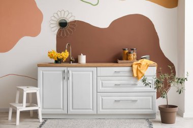 Çiçek açan narsist çiçeklerle süslenmiş şık bir mutfak.