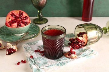 Taze nar ve beyaz masada bir bardak meyve suyu.