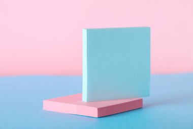 Pembe duvarın yanındaki mavi masaya yapışkan notlar.